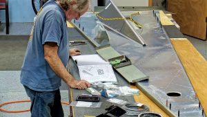 Assembling the torque tube bearing and cable fairleads onto the jump seat front and rear channels