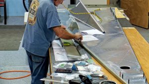 Assembling the torque tube bearing and cable fairleads onto the jump seat front and rear channels