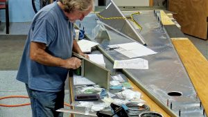 Assembling the torque tube bearing and cable fairleads onto the jump seat front and rear channels