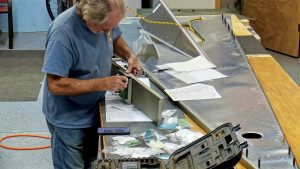 Assembling the torque tube bearing and cable fairleads onto the jump seat front and rear channels