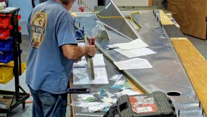 Assembling the torque tube bearing and cable fairleads onto the jump seat front and rear channels