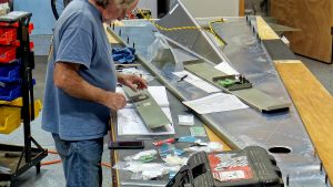 Assembling the torque tube bearing and cable fairleads onto the jump seat front and rear channels