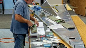 Assembling the torque tube bearing and cable fairleads onto the jump seat front and rear channels