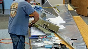 Assembling the torque tube bearing and cable fairleads onto the jump seat front and rear channels