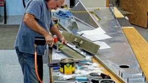 Assembling the torque tube bearing and cable fairleads onto the jump seat front and rear channels