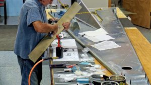 Assembling the torque tube bearing and cable fairleads onto the jump seat front and rear channels